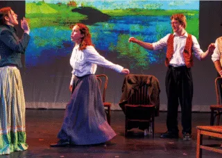 people on stage, chairs near 